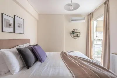 a bedroom with a bed with purple and white pillows at Serene 2BR Apartment in Alimos with Sea view by UPSTREET in Athens