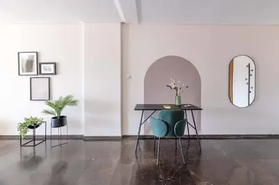 a table with a green chair and a mirror at Serene 2BR Apartment in Alimos with Sea view by UPSTREET in Athens