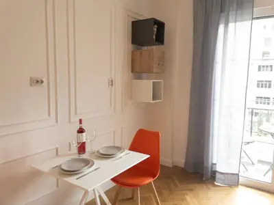 a dining room with a white table and a red chair at NobleNotes - Victor Suite Central Athens in Athens