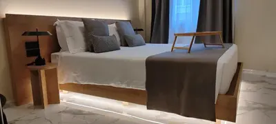 a bedroom with a large bed with a chair on it at Potnia Athens in Athens