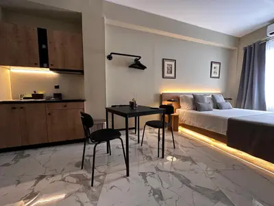 a bedroom with a bed and a table and chairs at Potnia Athens in Athens