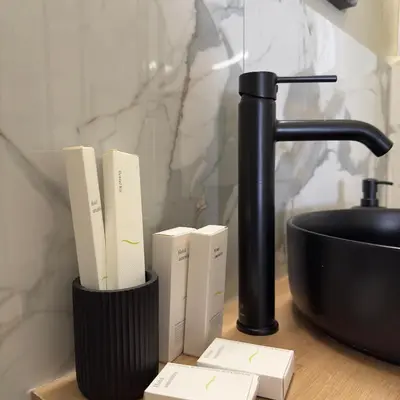 a black holder with books on a counter next to a sink at Potnia Athens in Athens