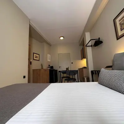 a bedroom with a bed and a dining room at Potnia Athens in Athens