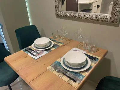 a wooden table with plates and glasses and a mirror at Apartment 55 Fix in Athens