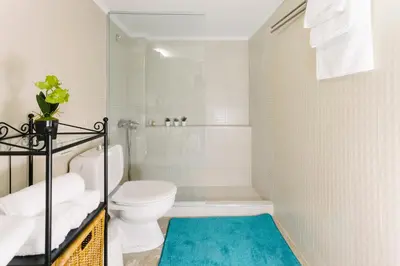 a bathroom with a toilet and a blue rug at Acropolis view apartment in Athens in Athens