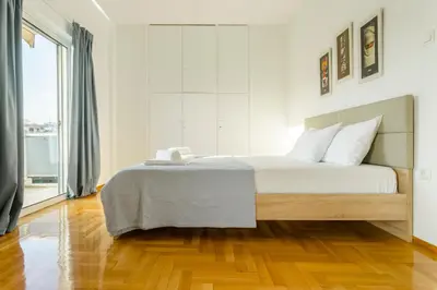 a bedroom with a large bed and a wooden floor at Acropolis view apartment in Athens in Athens