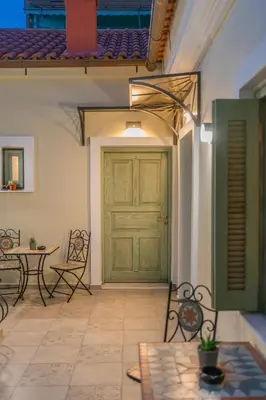 a patio with a green door and a table and chairs at The Stone Manor , Noho boutique Thissio in Athens