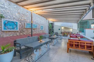 a patio with benches and tables and a couch at The Stone Manor , Noho boutique Thissio in Athens