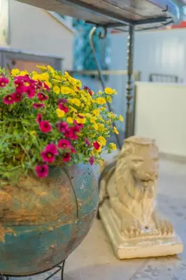 a vase filled with flowers sitting next to a statue at The Stone Manor , Noho boutique Thissio in Athens