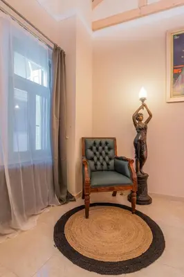 a chair in a living room with a lamp at The Stone Manor , Noho boutique Thissio in Athens