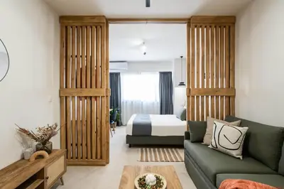 a living room with a bed and a green couch at KOYO Athens in Athens