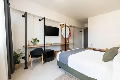 a bedroom with a bed and a desk and a tv at KOYO Athens in Athens