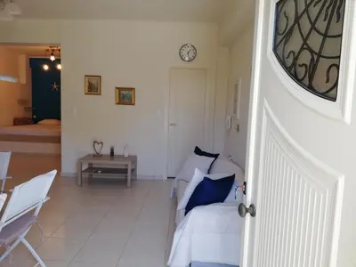 a living room with a couch and a clock on the wall at ALTHEA HOLIDAY STUDIO in Aghia Marina