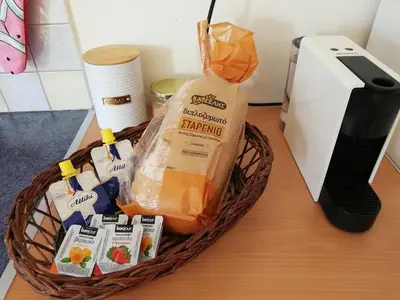 a basket of groceries sitting on a table next to a toaster at ALTHEA HOLIDAY STUDIO in Aghia Marina