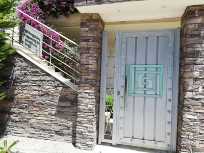 a front door of a house with a staircase and flowers at ALTHEA HOLIDAY STUDIO in Aghia Marina