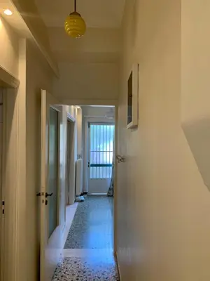 a hallway with a hallway leading into a room with a door at Lillian’s House in Athens
