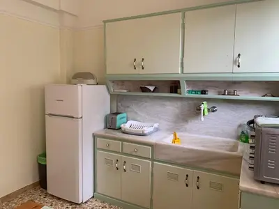 a kitchen with white cabinets and a white refrigerator at Lillian’s House in Athens
