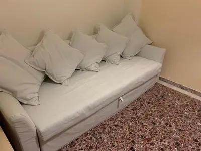 a white couch with four pillows on it at Lillian’s House in Athens