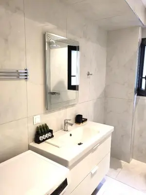 a white bathroom with a sink and a mirror at THE NEW Diamont of Athens in Athens