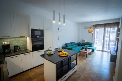 a kitchen and living room with a blue couch at NobleNotes - Isabella Suite Central Athens in Athens
