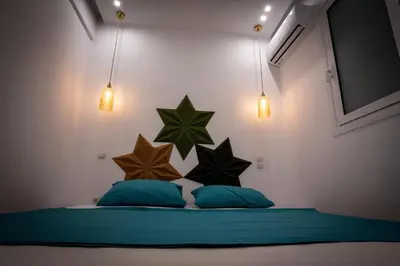 a bedroom with two pillows and stars on the wall at NobleNotes - Isabella Suite Central Athens in Athens