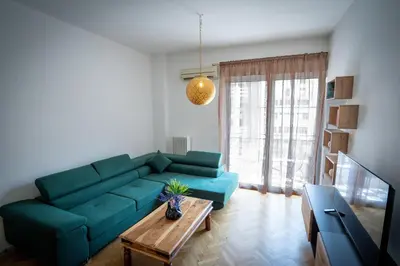a living room with a blue couch and a table at NobleNotes - Isabella Suite Central Athens in Athens