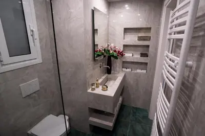 a bathroom with a sink and a toilet and a mirror at NobleNotes - Isabella Suite Central Athens in Athens