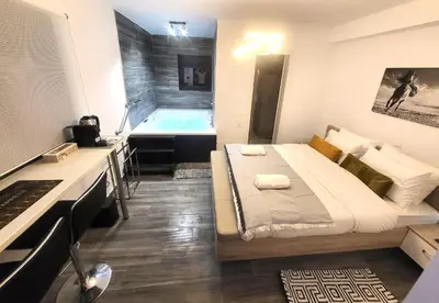a bedroom with a bed and a bath tub at Romantic Suite&GRANT Jacuzzi in Athens