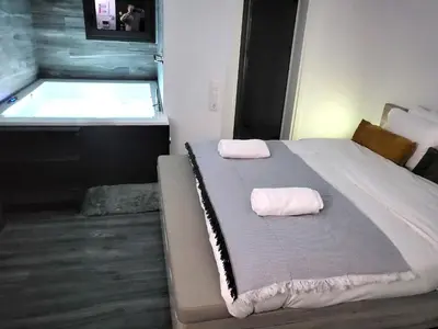 a bed with two pillows on it in a room with a tub at Romantic Suite&GRANT Jacuzzi in Athens