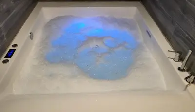 a bath tub filled with snow and blue water at Romantic Suite&GRANT Jacuzzi in Athens