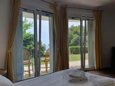 a bedroom with sliding doors to a patio with a bed at Sea Satin Anavyssos in Anavissos