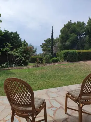 two chairs sitting on a patio with a lawn at Sea Satin Anavyssos in Anavissos