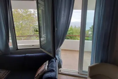 a room with a couch and a large window at Sea Satin Anavyssos in Anavissos