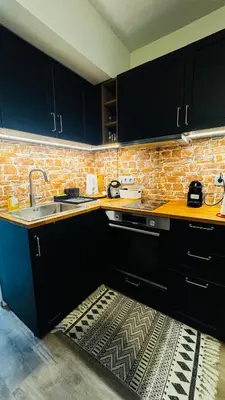 a kitchen with a sink and a brick wall at Urban escape in Athens in Athens