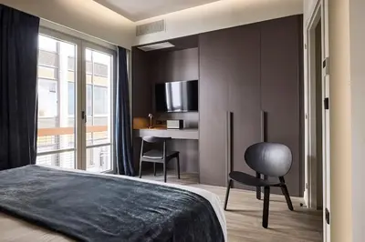 a bedroom with a bed and a desk and a chair at Athens Metropolitan Grand Residence in Athens