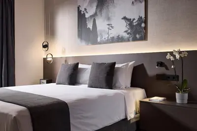 a bedroom with a large bed with white sheets and pillows at Athens Metropolitan Grand Residence in Athens