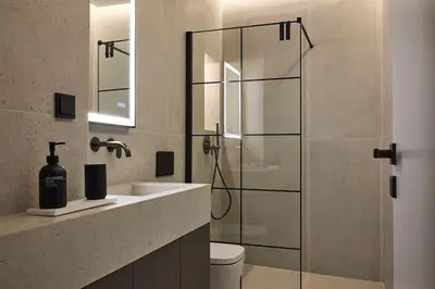 a bathroom with a shower with a sink and a toilet at Athens Metropolitan Grand Residence in Athens