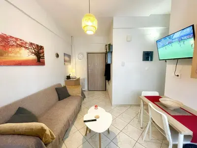 a living room with a couch and a flat screen tv at Modern & Quiet 4th Floor Flat - 3' from Metro in Athens