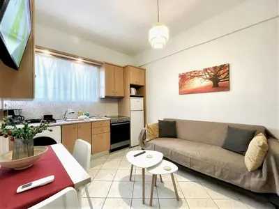 a living room with a couch and a kitchen at Modern & Quiet 4th Floor Flat - 3' from Metro in Athens