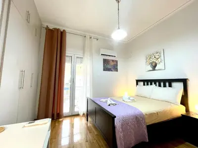 a bedroom with a large bed with a purple blanket at Modern & Quiet 4th Floor Flat - 3' from Metro in Athens