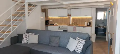 a living room with a blue couch and a kitchen at Spata center loft in Spáta