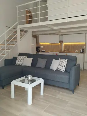 a living room with a blue couch and a table at Spata center loft in Spáta
