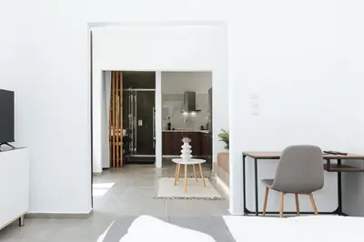 a living room with a table and a chair at Athena City Apartment in Athens