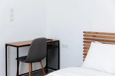 a bedroom with a desk and a chair next to a bed at Athena City Apartment in Athens
