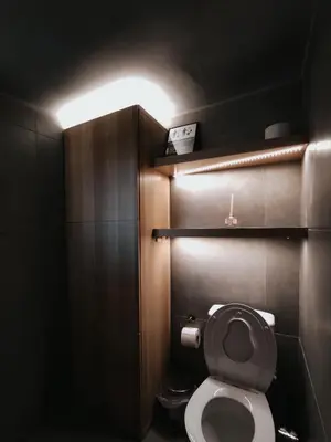 a bathroom with a toilet with a light above it at Athena City Apartment in Athens