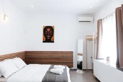 a bedroom with a bed with a large headboard at Athena City Apartment in Athens