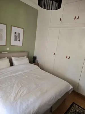 a bedroom with a white bed and white cabinets at Large 1 bedroom Penthouse with Large Terrace in Athens