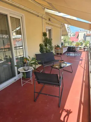 a patio with chairs and tables on a building at Large 1 bedroom Penthouse with Large Terrace in Athens