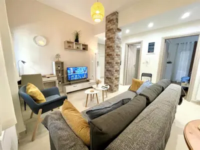a living room with a large couch and a tv at Elegant & Modern Flat Near Panathenaic Stadium in Athens