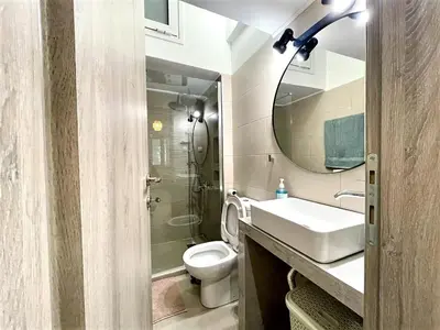 a bathroom with a toilet and a sink and a mirror at Elegant & Modern Flat Near Panathenaic Stadium in Athens
